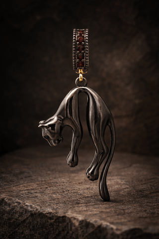 Black panther charm worn on gold chain necklace
