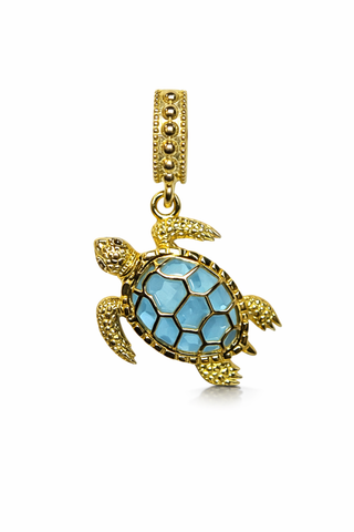 Ocean-inspired sea turtle charm with blue gemstone on gold necklace
