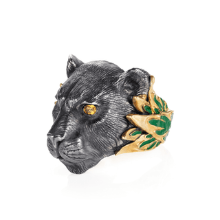 Panther head sculpture with gold and green accents on a white background